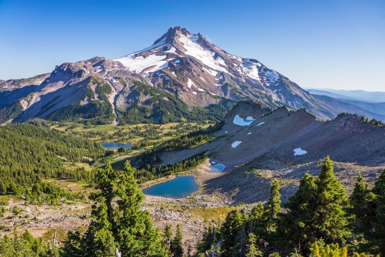 A high-altitude mountain landscape featuring a lake and a snow-capped peak—the ideal destination for sports camps and training camps